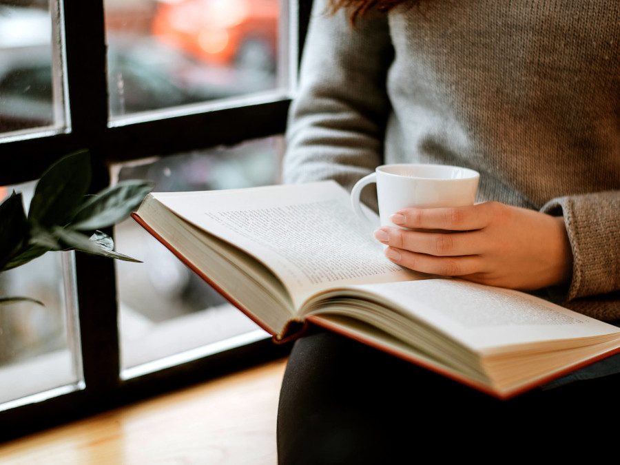 マグカップを片手に読書をする人